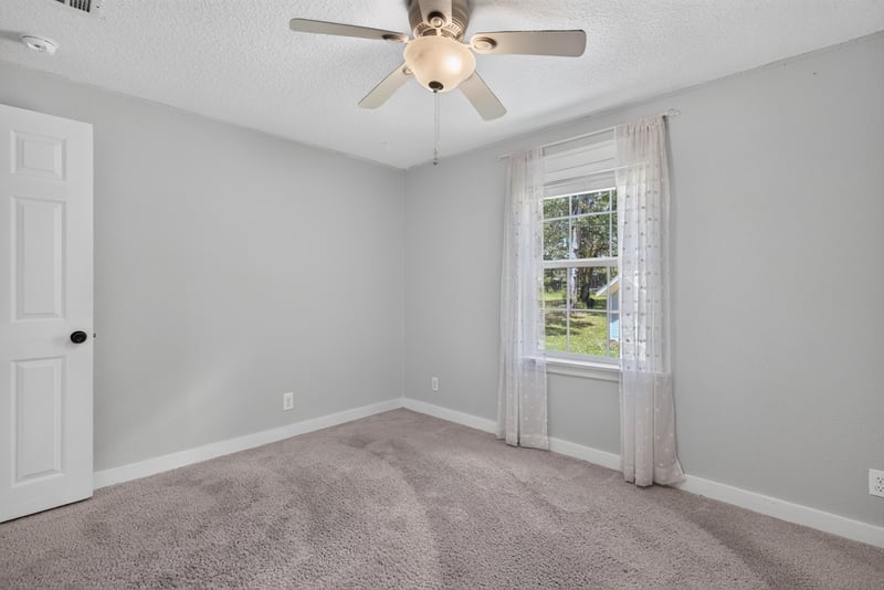 Bedroom with carpet and curtained window at 4890 McAllister Rd, Middleburg, FL 32068