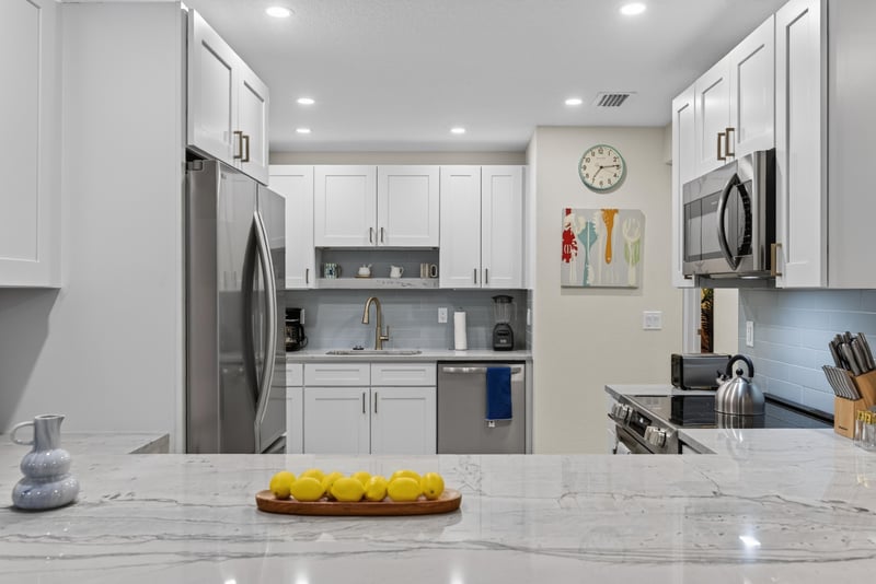 Kitchen with white cabinets and stainless refrigerator at 1525 8th St N, Jacksonville Beach, FL