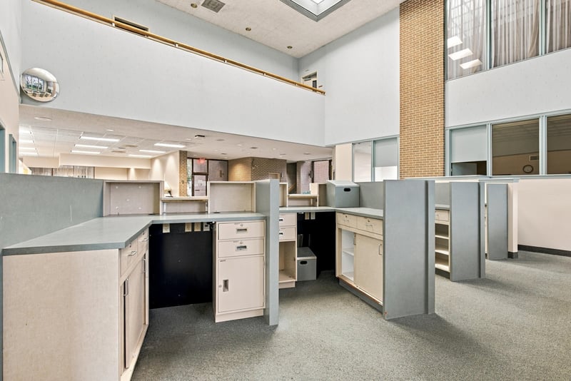 Cubicle workstations with brick accent wall at 101 Scholars Wy