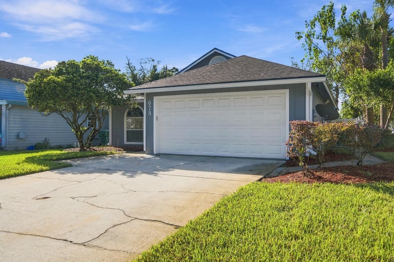 Front exterior with garage and lawn at 678 5th Ave N, Jacksonville Beach, FL 32250