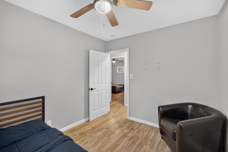 Bedroom with leather chair and wood-look flooring at 9506 Harriet Ave, Jacksonville, FL 32208
