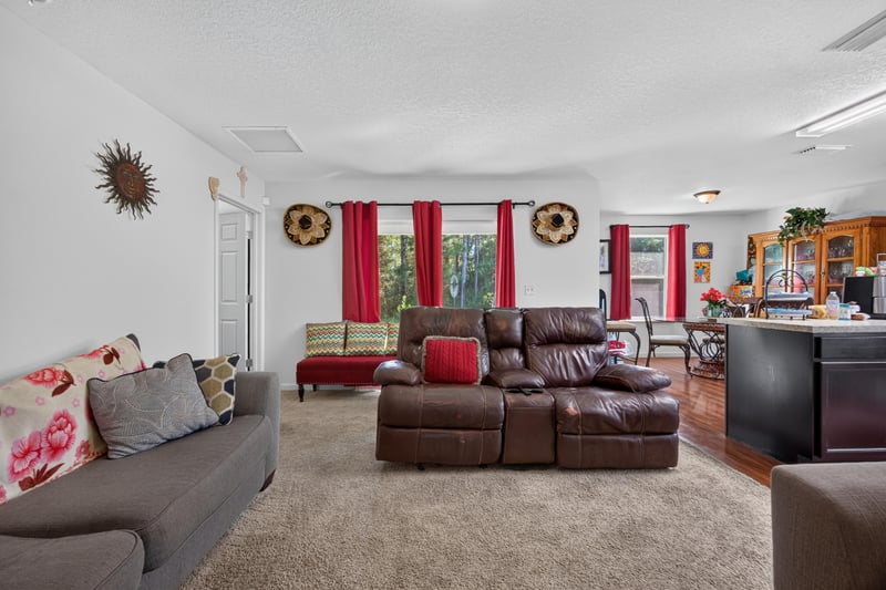 Living room seating area with red curtains at 518 Matecumbe Ct, Macclenny, FL