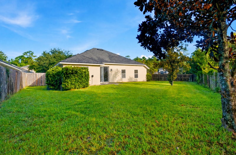 Backyard with mature trees and fenced perimeter at 14187 Big Spring St, Jacksonville, FL 32258