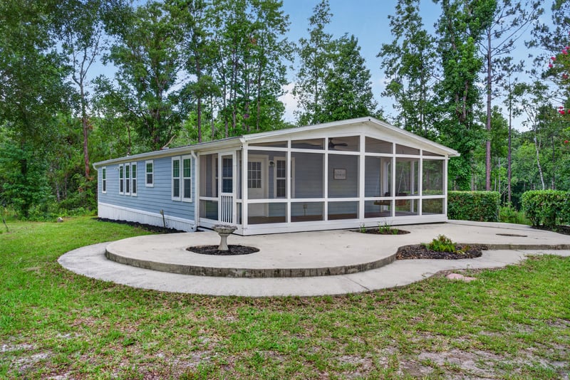 Aerial angled view of home with screened porch and curved patio at 4890 McAllister Rd, Middleburg, FL 32068