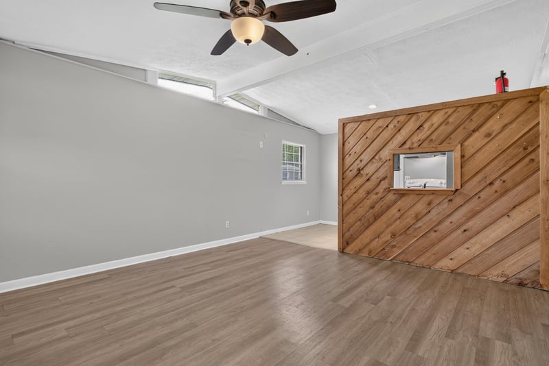 Living room with ceiling fan and wood accent wall at 255 Woodside Dr, Orange Park, FL 32073