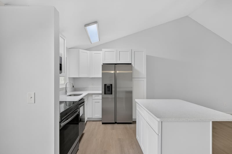 Kitchen with white cabinets and stainless refrigerator, unfurnished at 8177 Virgo St, Jacksonville, FL 32216