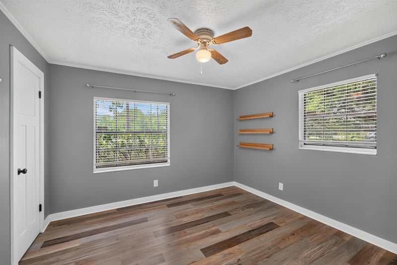 Bedroom with two windows and wall shelving at 6757 Deer Springs Rd, Keystone Heights, FL 32656