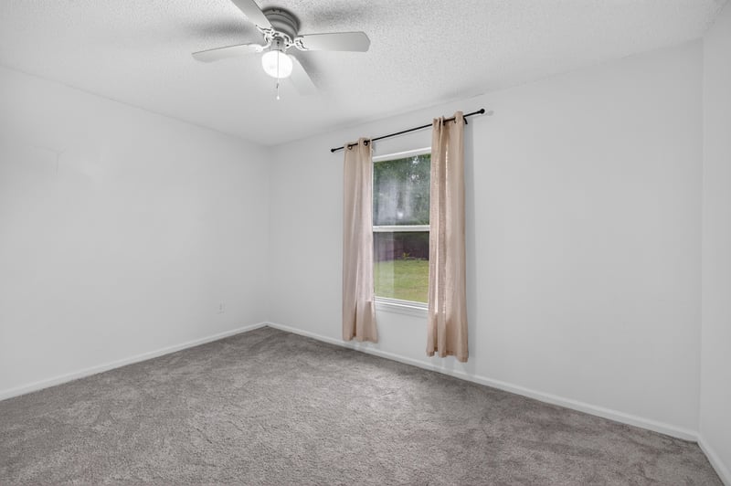 Empty carpeted room with curtained window at 8921 Needlepoint Pl, Jacksonville, FL 32244