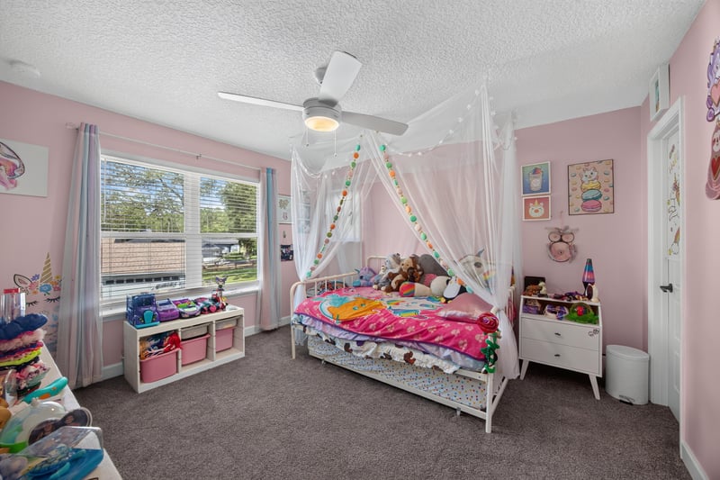 Bedroom with canopy bed and pink walls at 2817 Camel Cir, Middleburg, FL