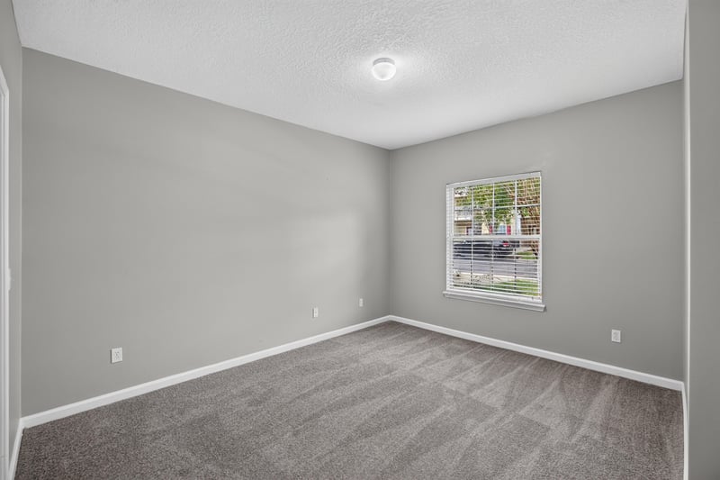 Second bedroom with window and carpet at 575 Oakleaf Plantation Pkwy, Orange Park, FL 32065