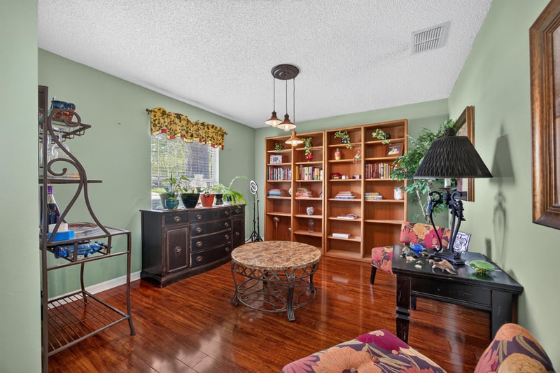 Living room with built-in bookshelf and wood floors at 145 Dover Bluff Dr, Orange Park, FL