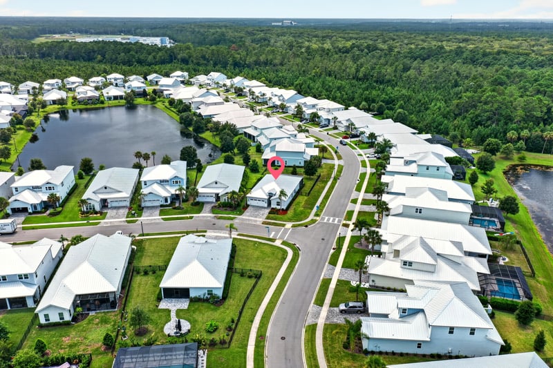Drone view of Tilloo Ct with the home pinned beside a pond in Beachwalk, St. Johns, FL