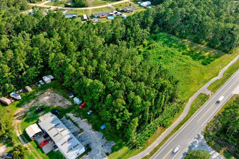 Aerial of the wooded lot along a curve of Co Rd 218 at 4393 Co Rd 218, Middleburg, FL 32068