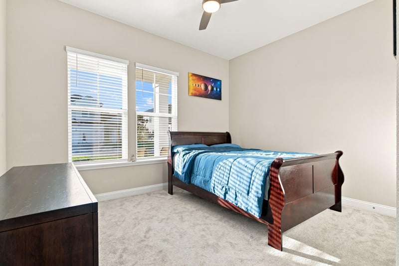 Secondary bedroom with wood bed frame and window at 27 Holly Rdg Wy, St. Augustine, FL