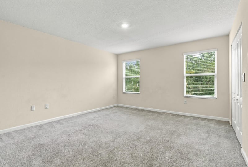 Empty bedroom with carpet and two windows at 9555 Star Dr, Jacksonville, FL 32256