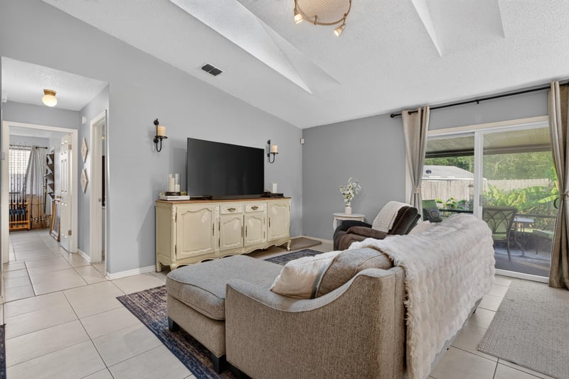 Living room with TV and sliding glass door at 13020 Medford Ln, Jacksonville, FL 32225