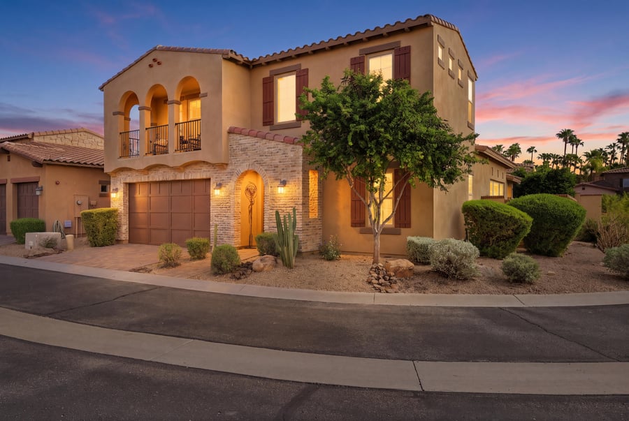 Virtual twilight of a two-story Tuscan-style home with arched balconies