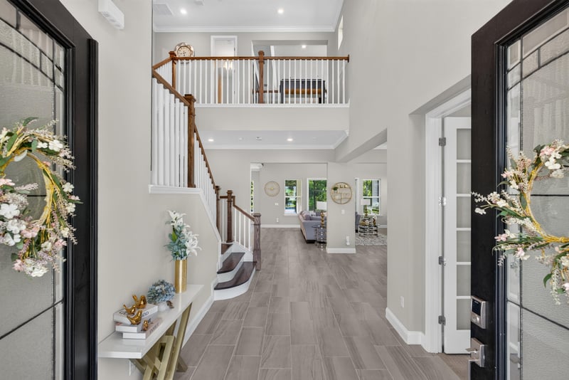 Foyer view with staircase and front door wreath at 22 Azura Point