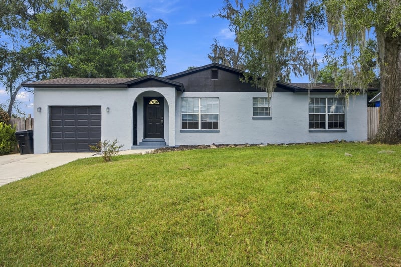 Front exterior with arched entry and lawn at 417 Capricorn Ln, Orange Park, FL 32073