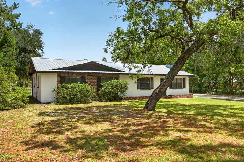 Front exterior showing metal roof and brick accents at 6757 Deer Springs Rd, Keystone Heights, FL 32656