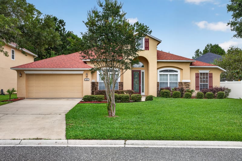 Front exterior with tile roof and two-car garage at 635 Wakeview Dr, Orange Park, FL 32065