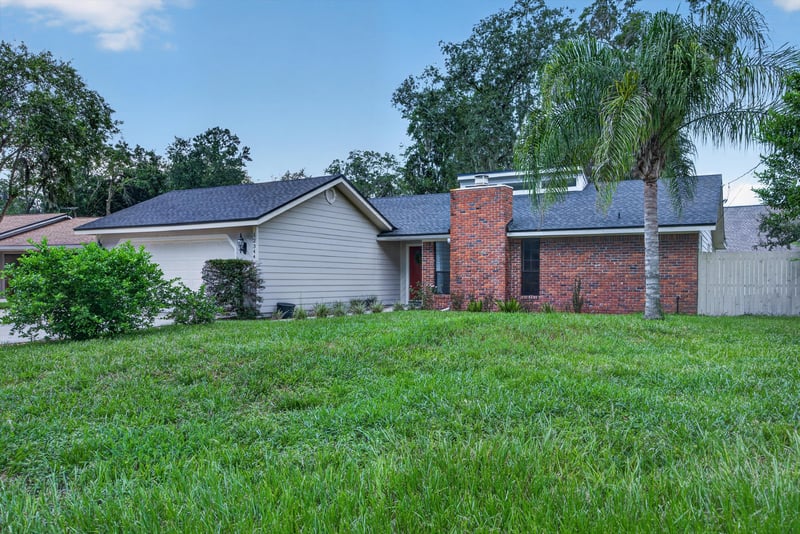 Front exterior at day-to-dusk with brick chimney at 12344 Cormorant Ct, Jacksonville, FL
