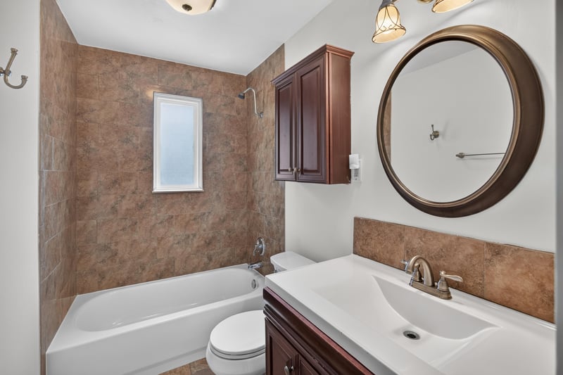 Bathroom with tub-shower combo and round mirror at 4039 Habana Ave, Jacksonville, FL