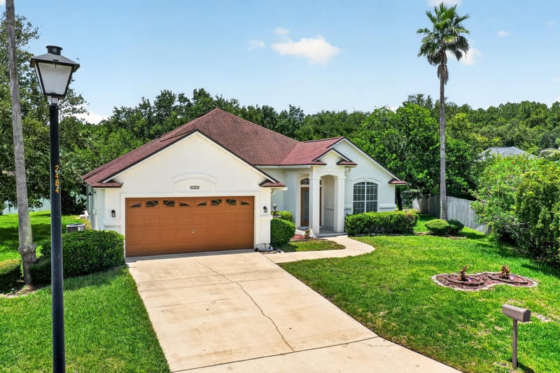 Front exterior with street lamp and landscaped lawn at 2480 Ridge Will Dr, Jacksonville, FL 32246
