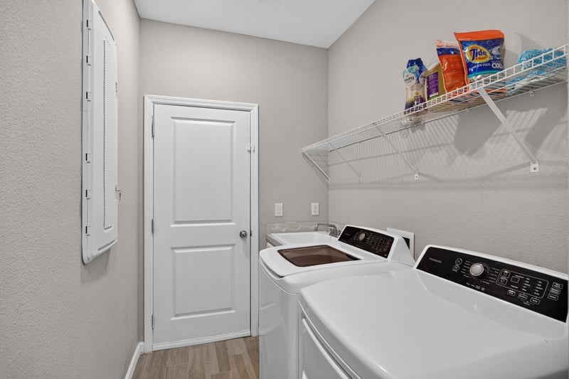 Hallway with door near laundry area at 9942 Lovage Ln, Jacksonville, FL 32219