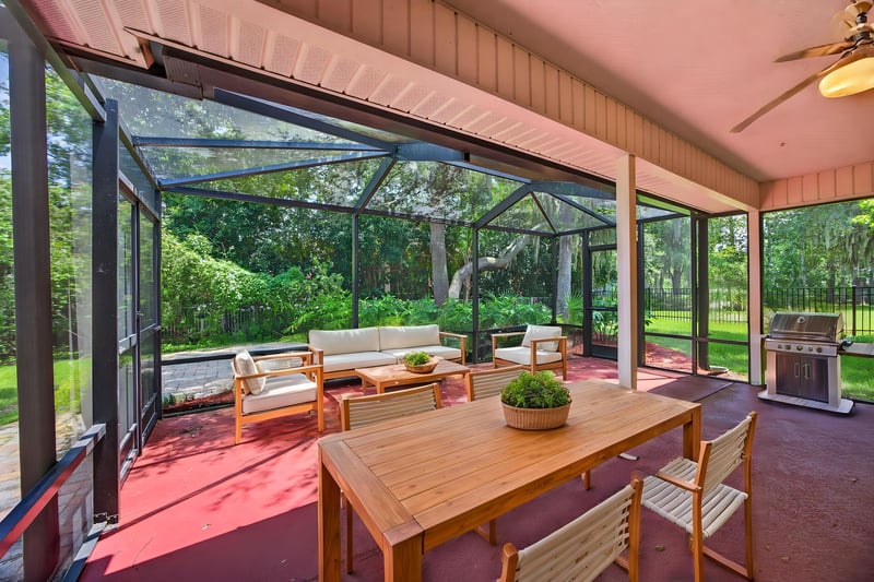 Screened porch furnished with seating and table at 1955 GUARDED Way, Fleming Island, FL 32003