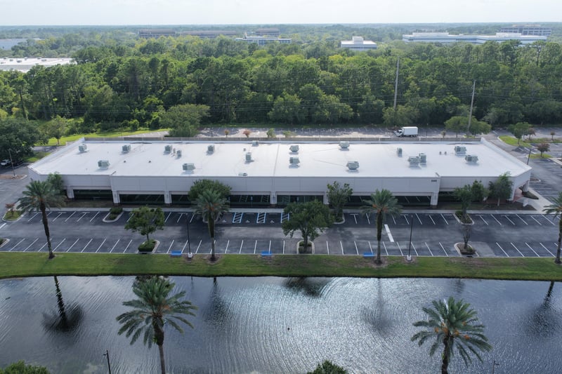 Aerial view of a roofline bordered by trees at 10550 Deerwood Park Blvd, Jacksonville, FL 32256