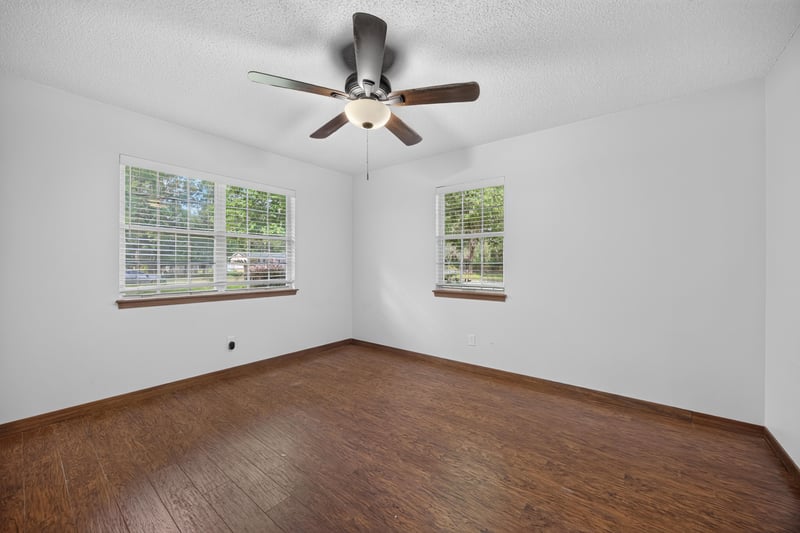 Bedroom with wood floors and two windows at 892 Branscomb Rd, Green Cove Springs, FL