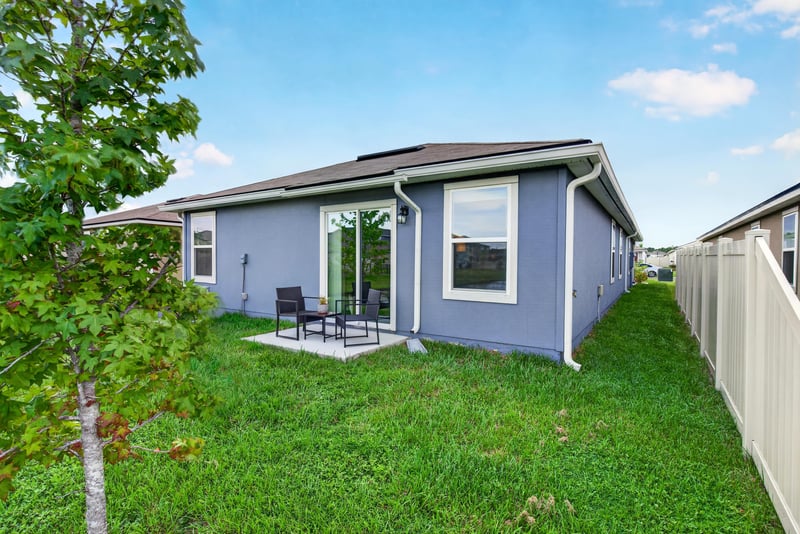 Rear exterior with patio furniture and fenced yard at 4276 Quaking St, Jacksonville, FL 32218