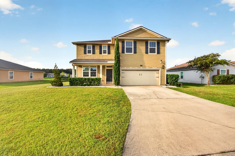 Front exterior from the driveway with shutters and lawn at 6830 Hanford St, Jacksonville, FL 32219