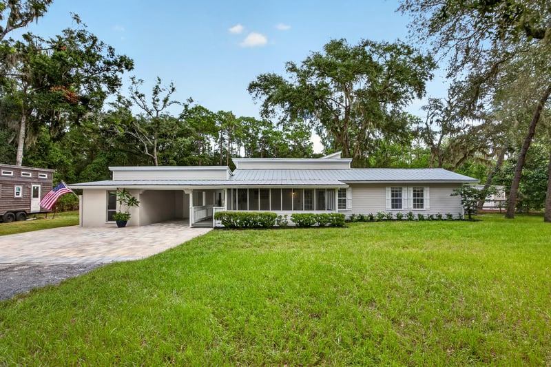Front exterior with carport and manicured hedges at 1161 Whispering Pines Rd, Jacksonville, FL 32259