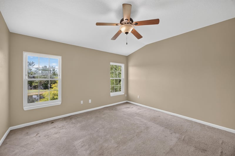 Bedroom with carpet, ceiling fan and two windows at 1572 Biscayne Bay Dr, Jacksonville, FL 32218