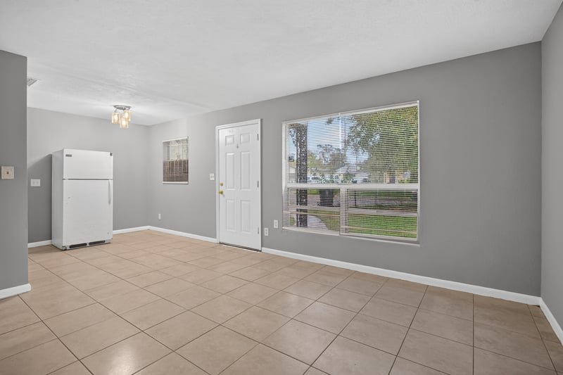 Empty living room with two windows and tile floor at 4030 Leonard Cir W, Jacksonville, FL 32209