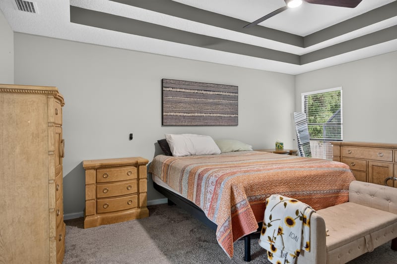 Bedroom with wood dresser and headboard at 2125 Blue Heron Cove Dr, Orange Park, FL 32003