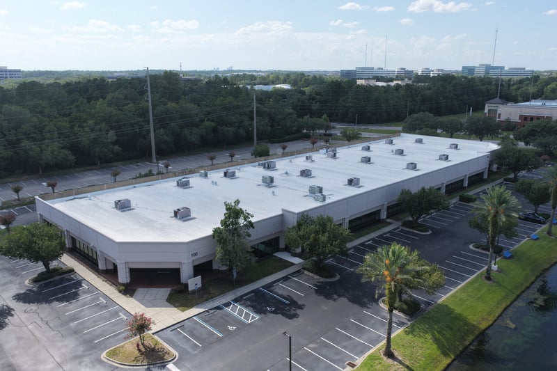 Aerial view of an L-shaped building roof and parking lot at 10550 Deerwood Park Blvd, Jacksonville, FL 32256