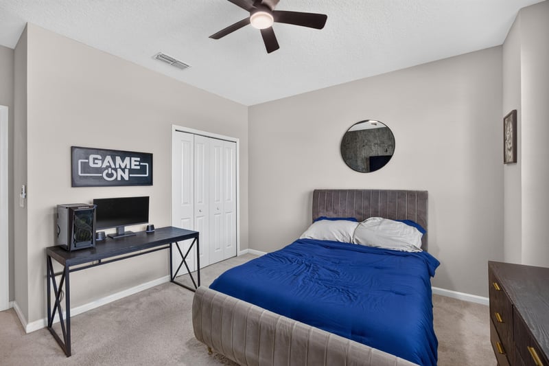 Secondary bedroom with desk and GAME ON sign at 9942 Lovage Ln, Jacksonville, FL 32219