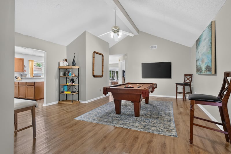 Living room with pool table and vaulted ceiling at 8680 Bandera Cir S, Jacksonville, FL 32244