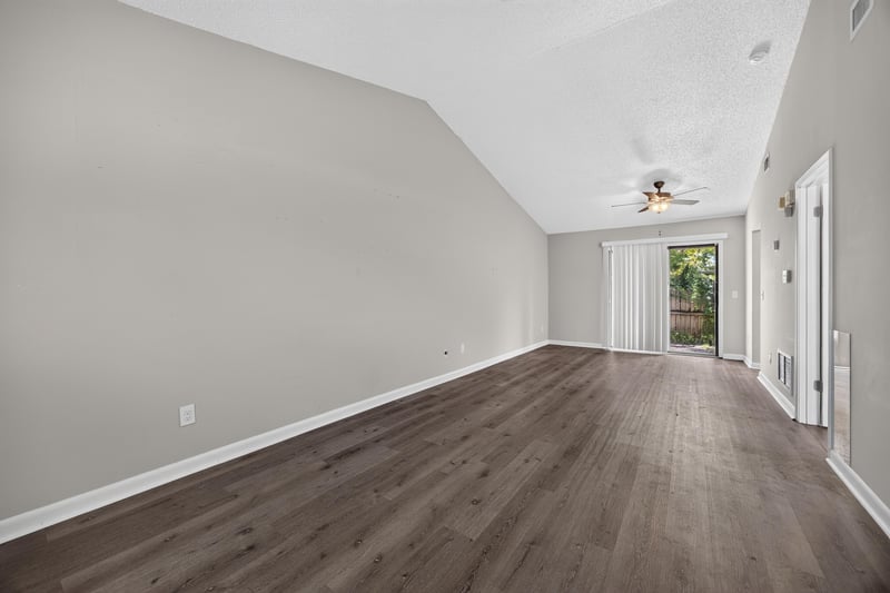 Living room with vaulted ceiling and wood-look flooring at 2719 Trollie Ln
