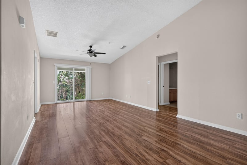 Vaulted living room with sliding glass door at 7047 Deer Lodge Cir, Jacksonville