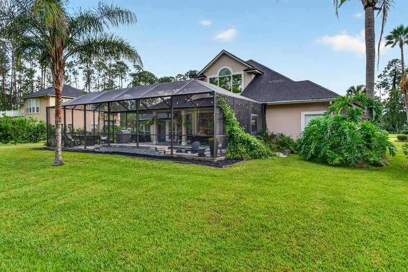 Back exterior with screened porch and open lawn at 2304 Spring Hill Ct, Orange Park, FL