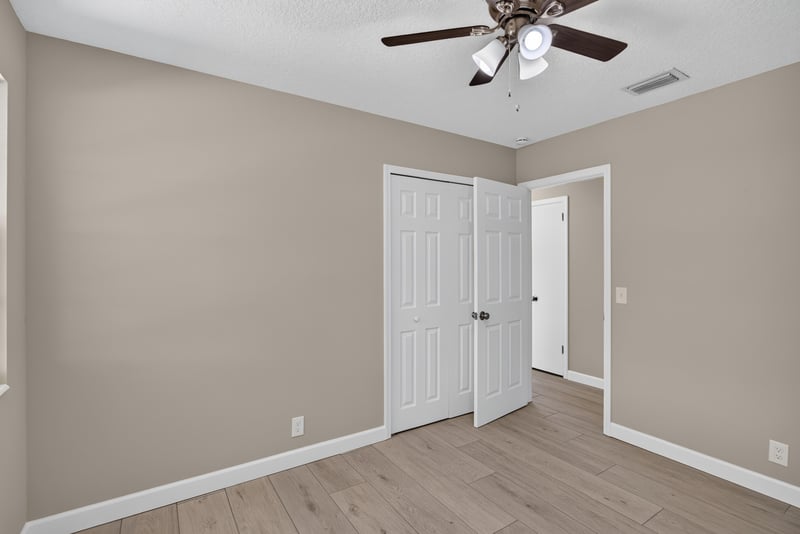 Hallway with closet doors and wood-look flooring at 4117 Wilcrest Ct, Jacksonville, FL 32277