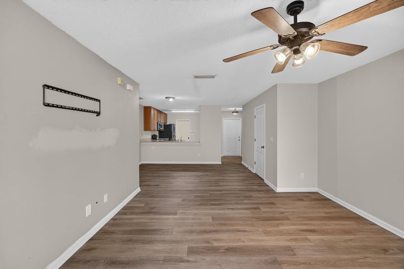 Open room with ceiling fan and kitchen view at 7723 Playschool Ln, Jacksonville, FL