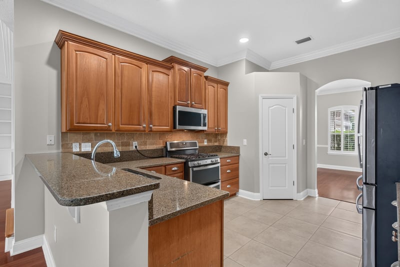 Kitchen island with microwave and wood cabinets at 4109 Eagle Landing Pkwy, Orange Park, FL 32065