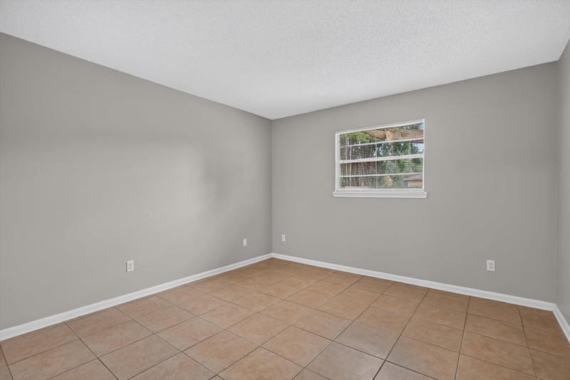 Bedroom with window and tile floor at 1040 Willow Cove Ct E, Jacksonville, FL 32233