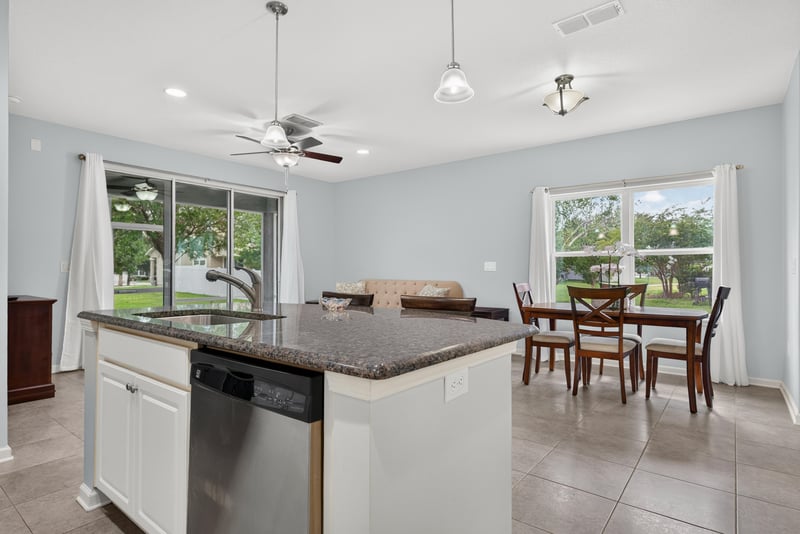 Kitchen island with dining table and windows beyond at 2378 Caney Oaks Dr, Jacksonville, FL