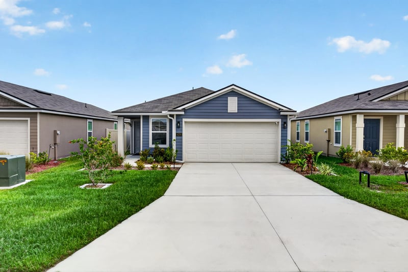 Front exterior with two-car garage and landscaped walkway at 4276 Quaking St, Jacksonville, FL 32218
